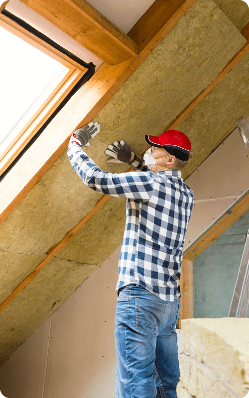 A contractor performing insulation installation in a client's attic.