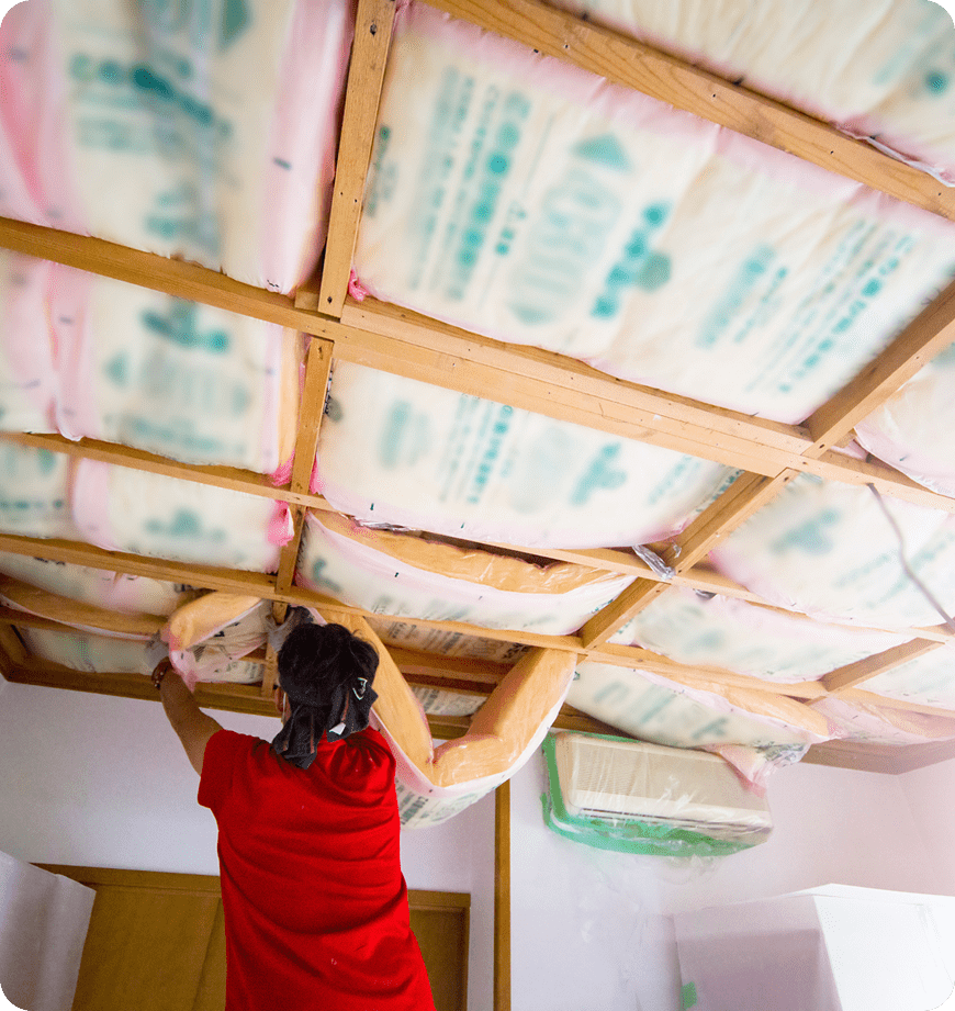 Technician providing insulation installation in a residential ceiling.