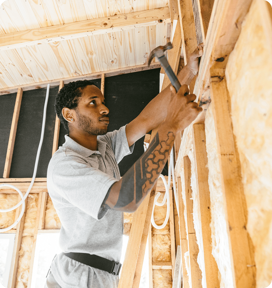 A professional nailing in new pieces after insulation installation.