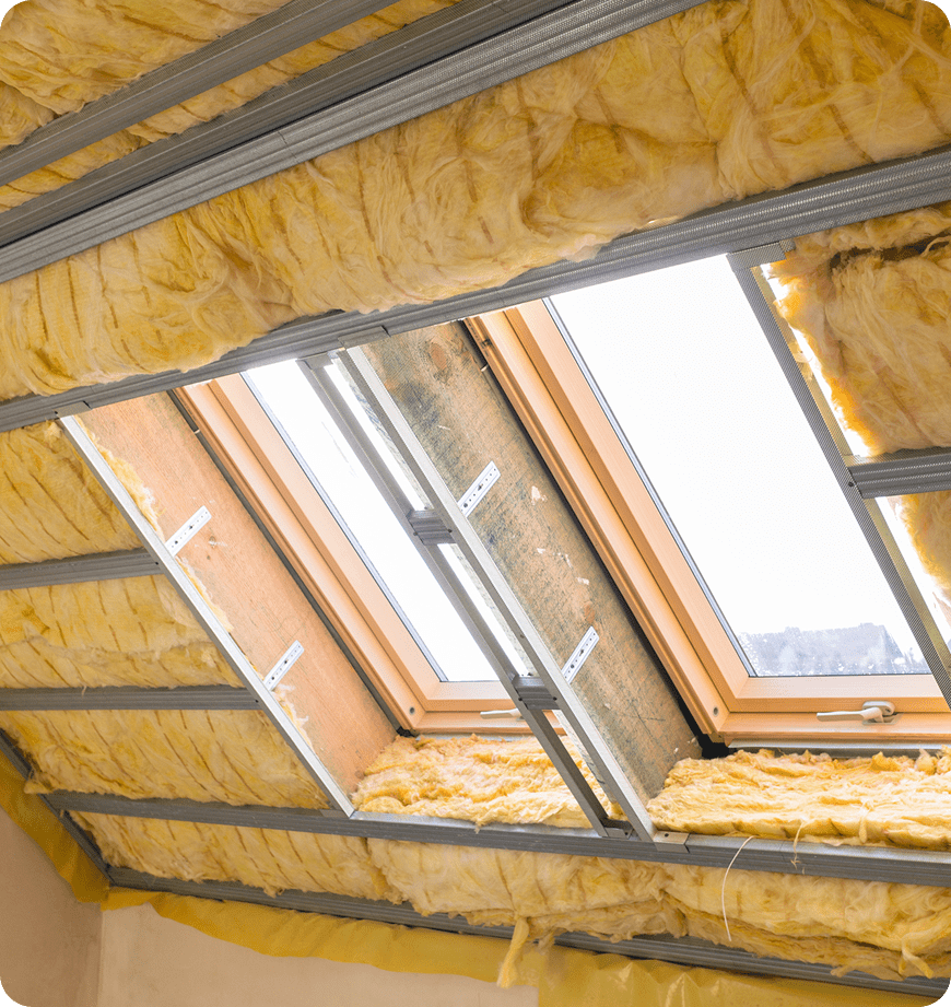 Attic insulation installation with skylight under construction by experts.
