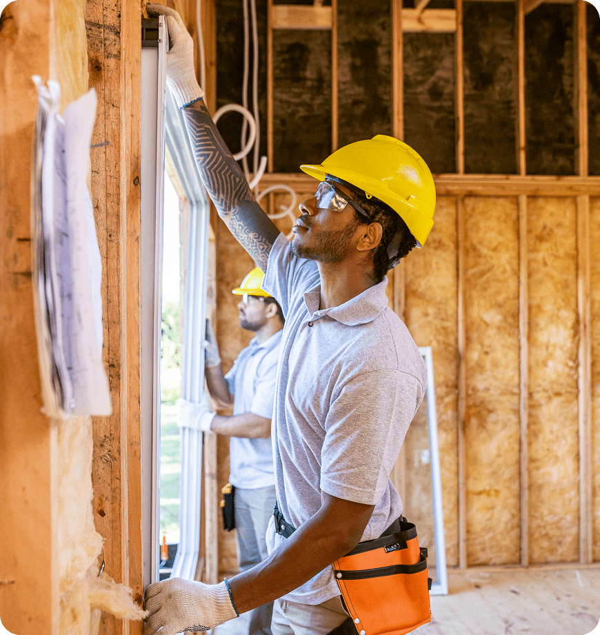 Construction workers installing a window frame in a client's home.