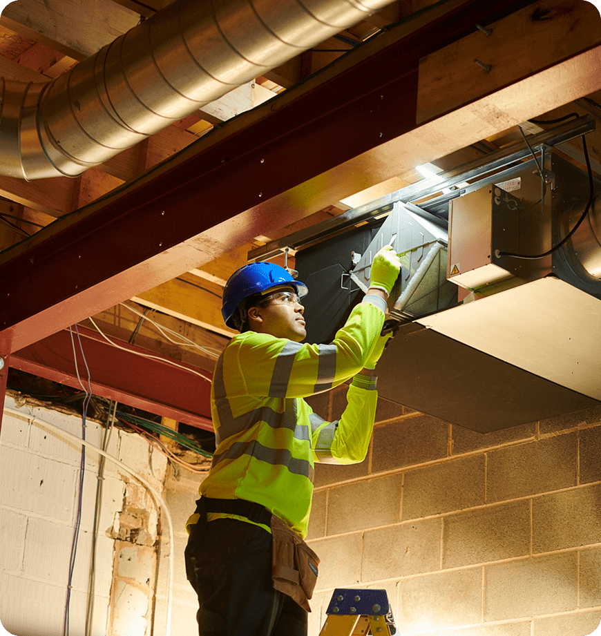 A professional performs duct replacements using tools and safety gear.