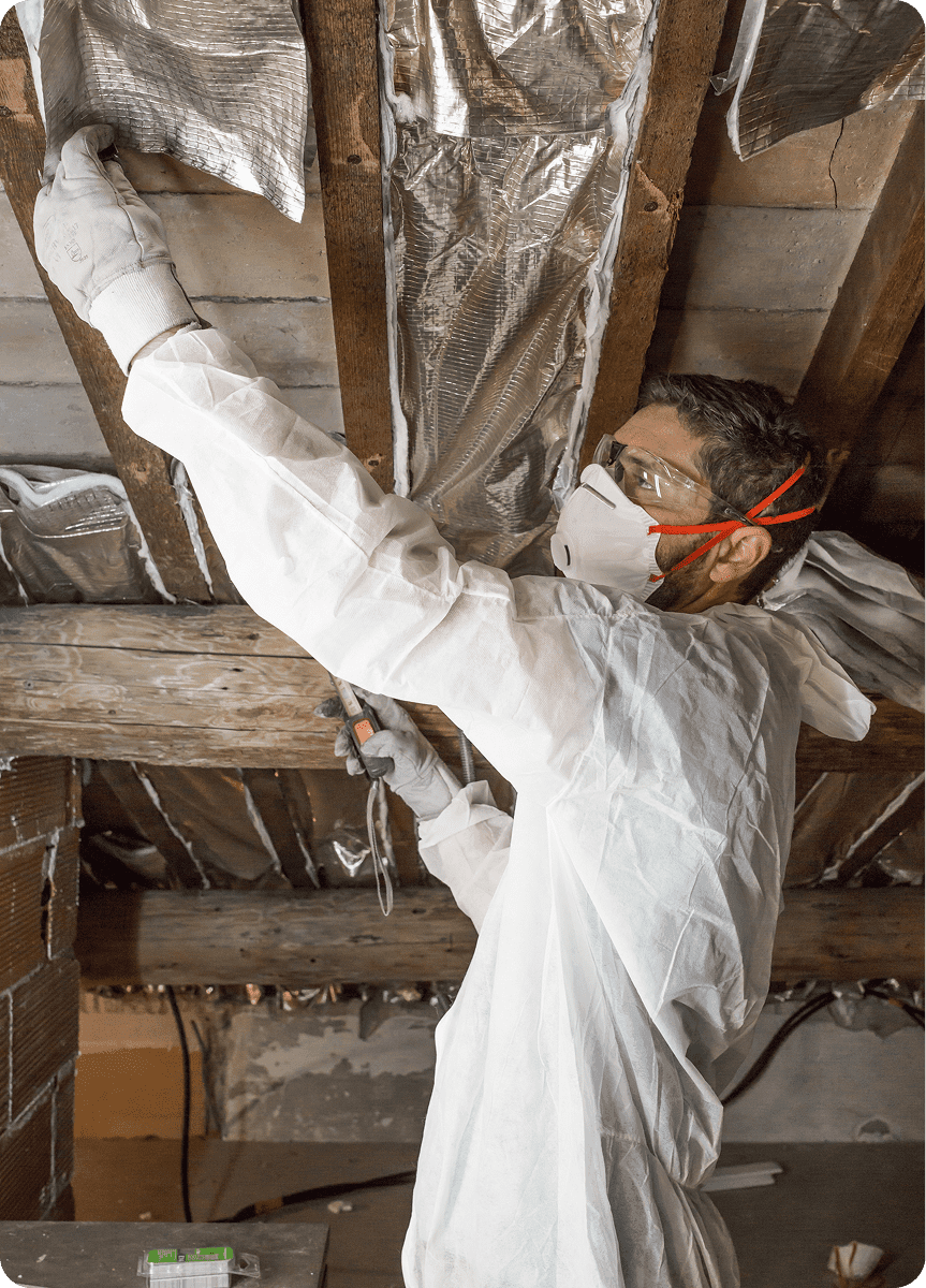 A man in a face mask installing attic ventilation