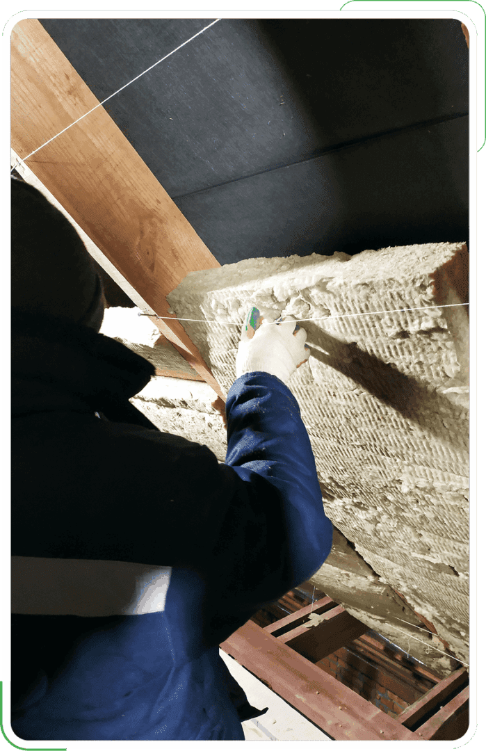 A man performing attic ventilation and sealing services for a residential property.