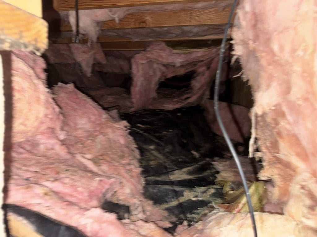 Attic space with exposed pink insulation.