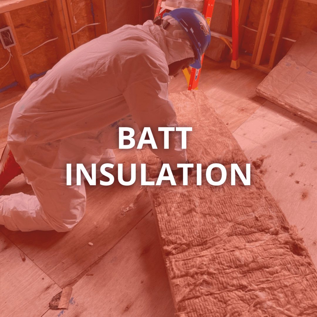 Worker installing batt insulation in attic