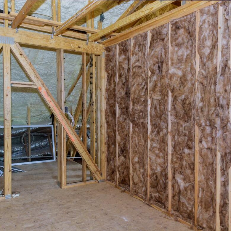 Wooden framework with insulation in unfinished room.
